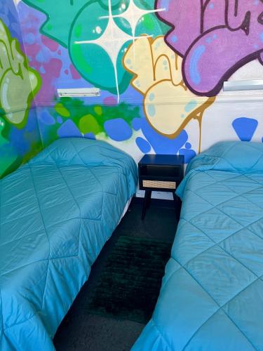 a room with two beds and a colorful wall at Central YMCA Residences in Honolulu