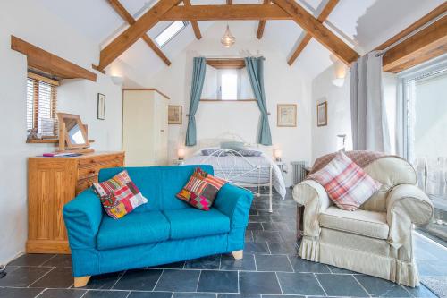 a living room with a blue couch and a chair at Y Sied in Newport