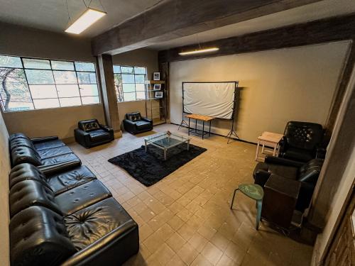 an overhead view of a living room with a couch and chairs at FRONTERA 49 Roma Norte Hostal in Mexico City