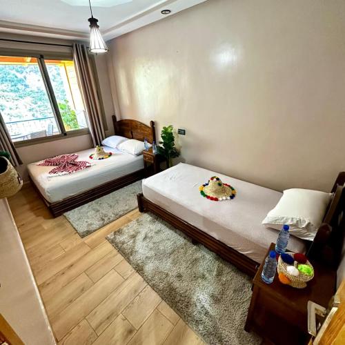 a bedroom with two beds and a table and a window at Akchour waterfalls in Akchour