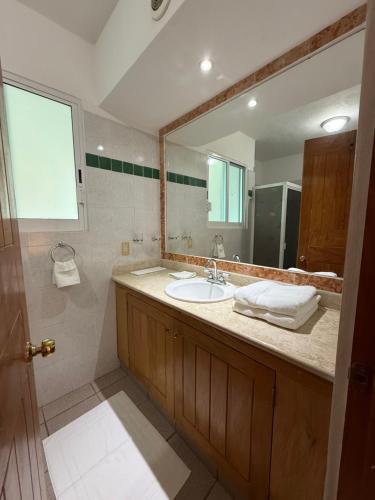 a bathroom with a sink and a large mirror at Ideal beach getaway in Nenúfares 2-101 in Nuevo Vallarta