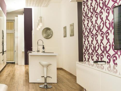 a kitchen with a white counter and a pink patterned wall at Basilica Apartments in Budapest
