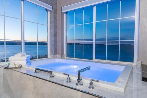 a bathroom with a large tub with a large window at Silver Cloud Hotel - Mukilteo Waterfront in Mukilteo