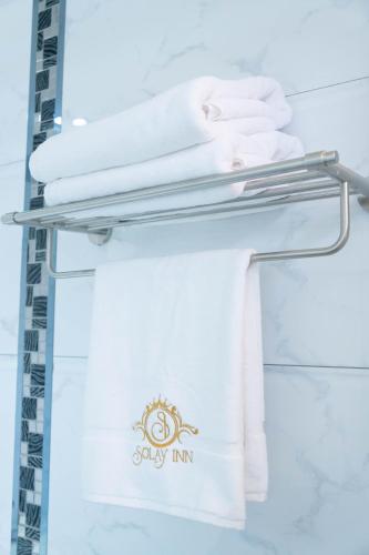 a towel rack with white towels on it at Solay Inn in Ayacucho