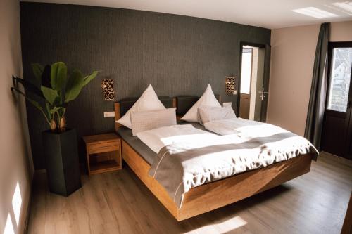 a bedroom with a large bed with white pillows at Gasthaus SEPP in Dernau