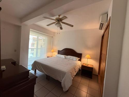 a bedroom with a bed and a ceiling fan at Ideal beach getaway in Nenúfares 2-101 in Nuevo Vallarta