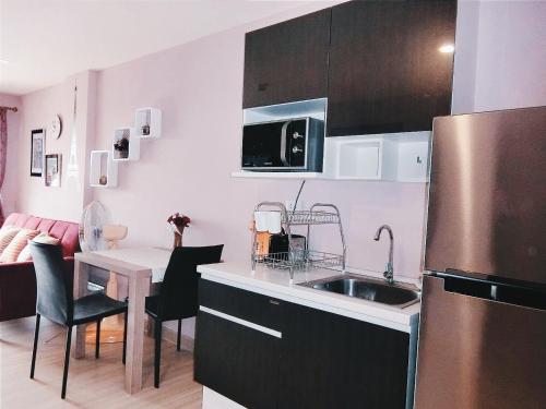 a kitchen with a refrigerator and a table with chairs at Bluroc Huahin 15/684 in Hua Hin