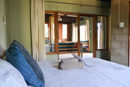 a white bed with blue pillows in a room at The Prawn Hatchery Pty Ltd on Amatikulu in Dokodweni