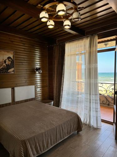 a bedroom with a bed and a large window at Villa Vi-Ta in Zatoka