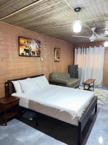 a bedroom with a large bed and a couch at Riverside Lodge Bansang in Bansang