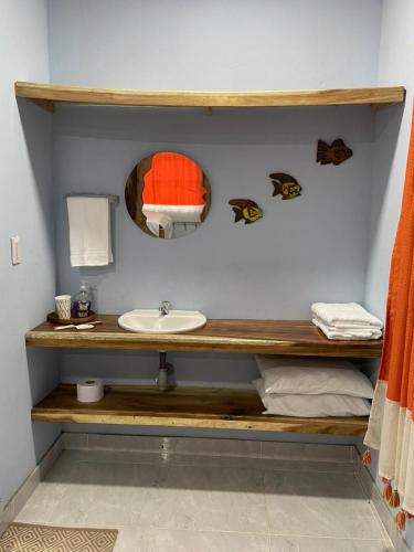ein Badezimmer mit Waschbecken und Spiegel in der Unterkunft Zéfiro Hostal in San Bernardo del Viento
