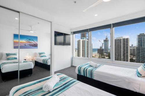 a bedroom with two beds and a view of the city at Q Tower Apartments - Hosted by Wow Stay in Gold Coast