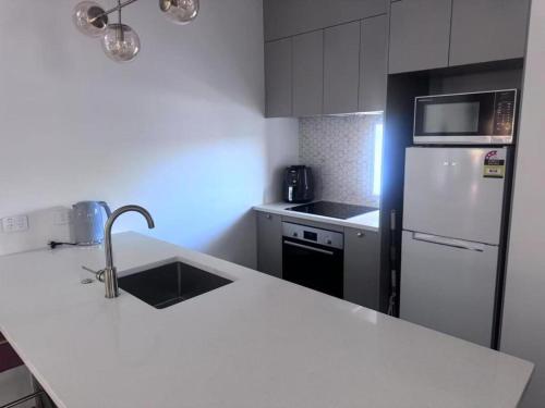 a kitchen with a white counter and a refrigerator at Two Bedroom Apartment in Auckland