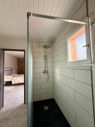 a glass shower in a room with a bedroom at Gîte 2 suites proche du lac de Chalain in Montigny-sur-lʼAin