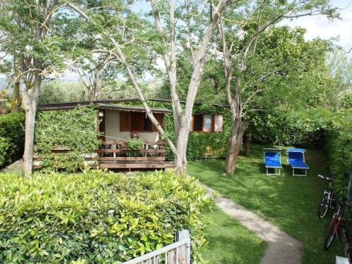 a house with two blue chairs in the yard at Apartment Haus Jasmin by Interhome in Castagneto Carducci