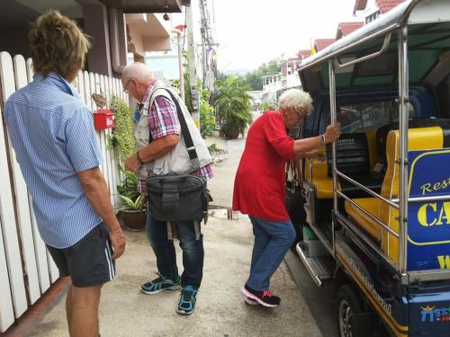 a group of three people standing around a bus at Chomhaad Guesthouse in Hua Hin