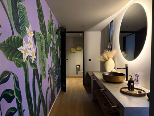 a bathroom with a large mural of flowers on the wall at La Font Ecolodge in Buenavista