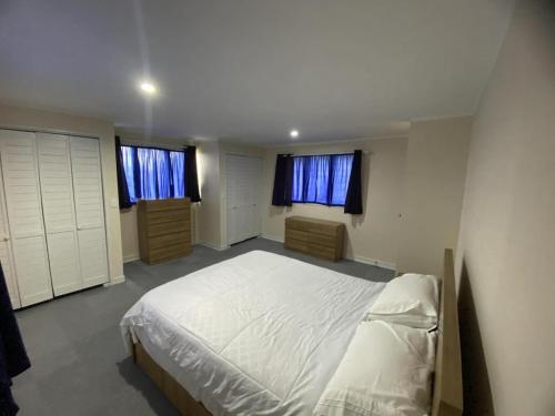 a bedroom with a white bed and two windows at Lagoon House in Veitongo