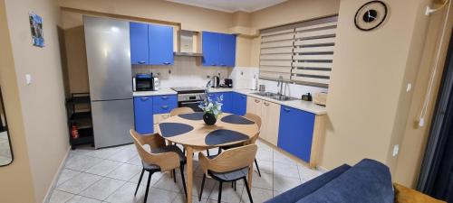 una cucina con armadi blu, tavolo e sedie di Dramas17 - PS5 a Pireo