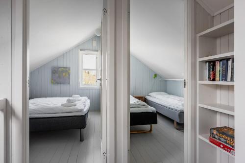 a small bedroom with two beds and a window at Skottinden Panorama Lofoten in Ballstad