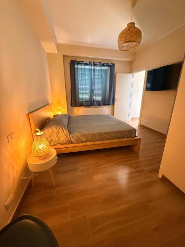 a bedroom with a bed and a table and a window at Al vico1 in Campo Calabro