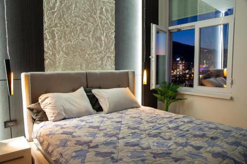 a bedroom with a large bed with a window at Stone Bridge 24 Apartment in Skopje