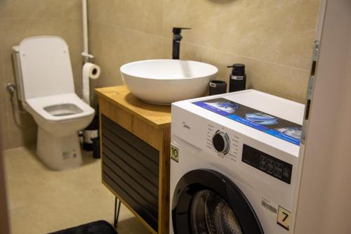 a bathroom with a washing machine and a sink at Stone Bridge 24 Apartment in Skopje