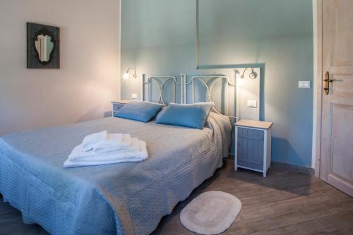 a blue bedroom with a bed with towels on it at Casa Al Fiume in Ponti Sul Mincio