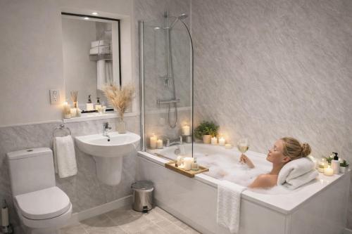 a woman sitting in a bath tub with candles at The Dark Hedges Hotel in Stranocum