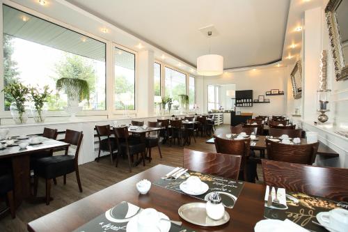a restaurant with tables and chairs and a large window at Arena Hotel in Gelsenkirchen