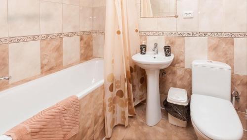 a bathroom with a sink and a toilet and a tub at Котедж "У Мадяра" in Mykulychyn