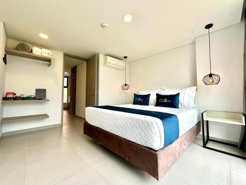 a bedroom with a large bed with blue pillows at Hotel ECO 44 in Medellín