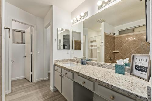 a bathroom with a sink and a large mirror at West Valley Pool Side Oasis in Surprise