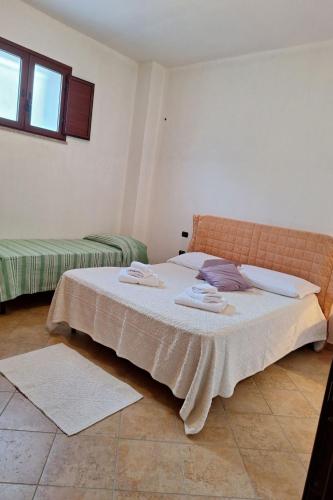 a bedroom with a large bed with towels on it at Apartment Manna Hof by Interhome in Irgoli