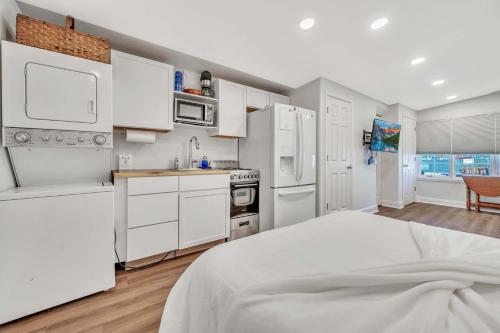 a white kitchen with white appliances and a bed at 127 Hwy 71 AT Bunk House in Arnolds Park