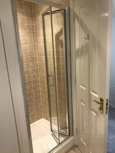 a shower with a glass door in a bathroom at Lakescape in Cirencester