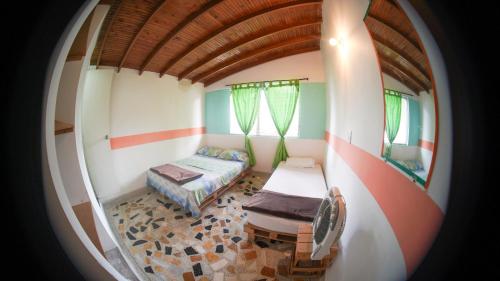 a small room with a bed and a window at Hostal Paz y Vida in Medellín