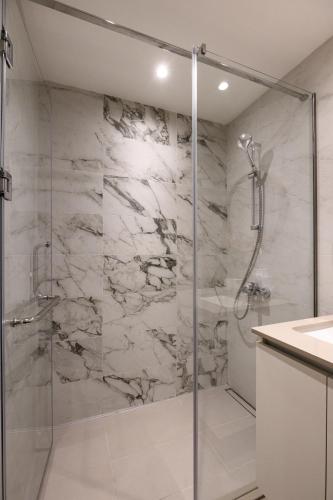 a bathroom with a shower with a glass door at inJoy in Sajmište