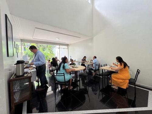 a group of people sitting at tables in a restaurant at Pousada Hospedar Imperial in Campina Grande