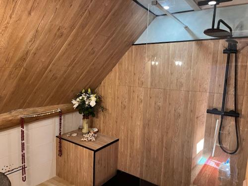 a bathroom with a shower and a vase of flowers on a table at La Riviere Esperance in Veyrignac