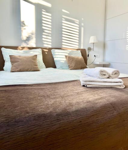 a bedroom with a large bed with white sheets and pillows at Apartments KIDS in Kaštela
