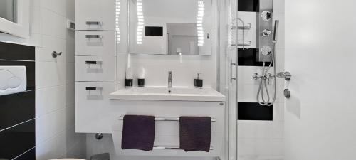 a white bathroom with a sink and a shower at Villa Kasandra - Ruhe & Eleganz in Buje, Istrien in Kaštel