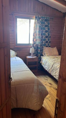 a bedroom with two beds and a window at Atardecer Inolvidable in Tomé