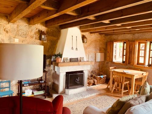 a living room with a fireplace and a table at Refúgio da Póvoa Dão in Silgueiros