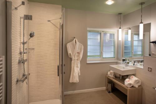 a bathroom with a shower and a sink at Domitys - Le Carillon d'or in Maubeuge