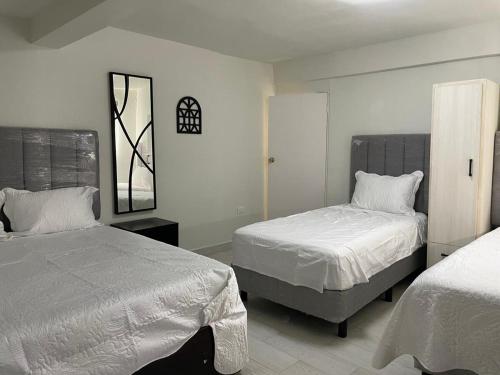 a bedroom with two beds and a mirror at Casa 3 super centrica ubicada al norte in Hermosillo