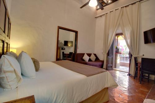 a bedroom with a large white bed and a mirror at Hotel Punto 79 in San Miguel de Allende