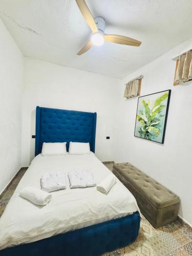a bedroom with a blue bed and a ceiling fan at VENICE by luxury Atitlan in San Pedro La Laguna