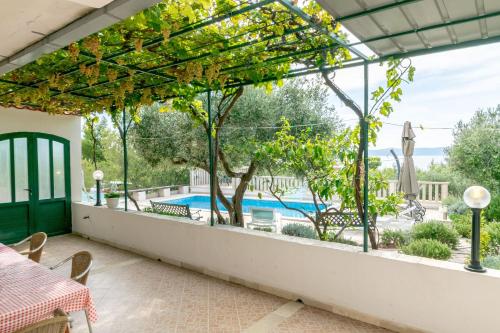 a patio with a view of a swimming pool through a window at House Ratac in Bol