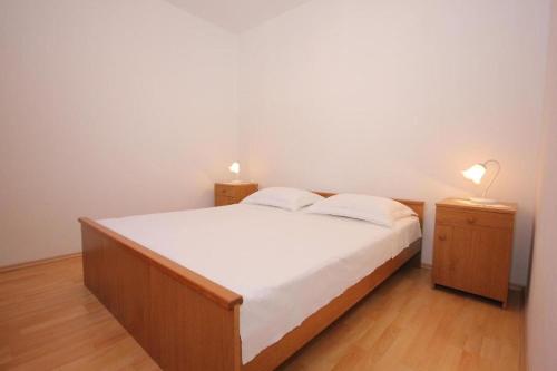 a bedroom with a bed and two night stands with lamps at House Paulo1 in Rogačić